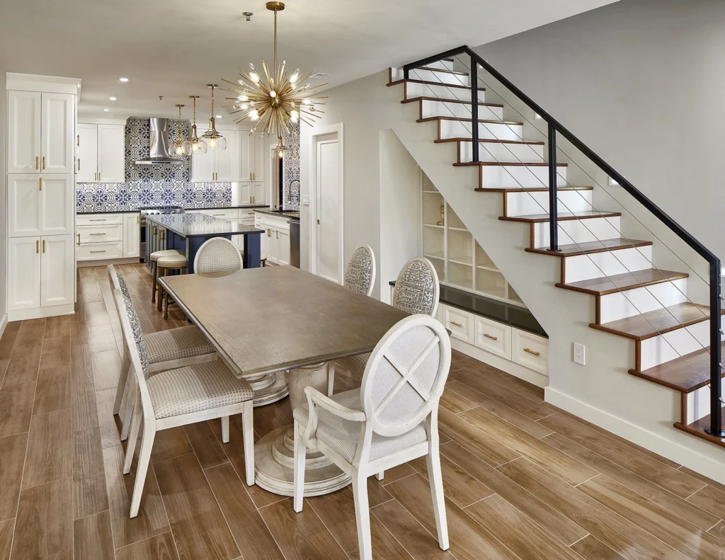 Open dining area and kitchen with modern staircase and built-in storage in the Travis remodel